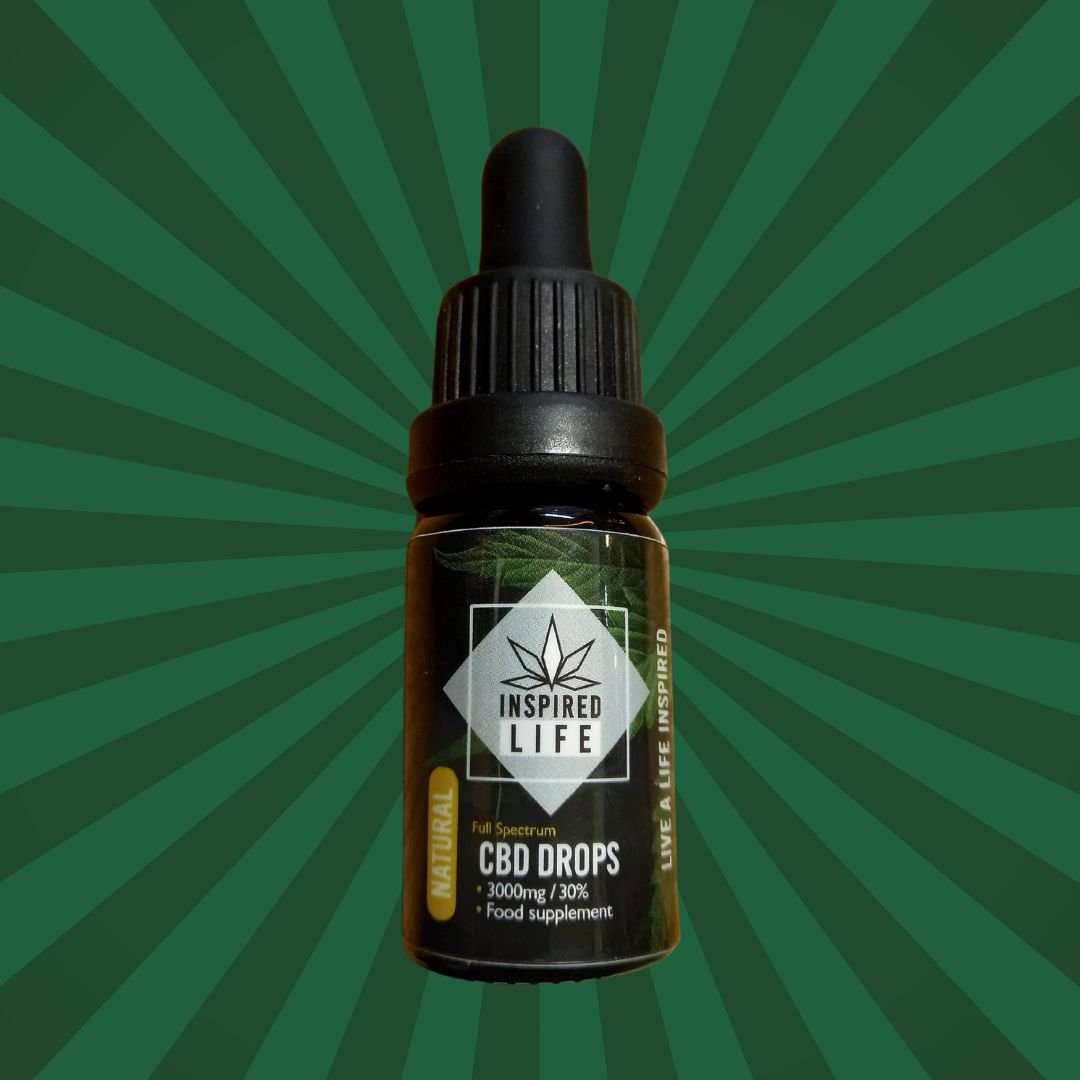 CBD oil dropper bottle with 'Inspired Life' label on a green radial background